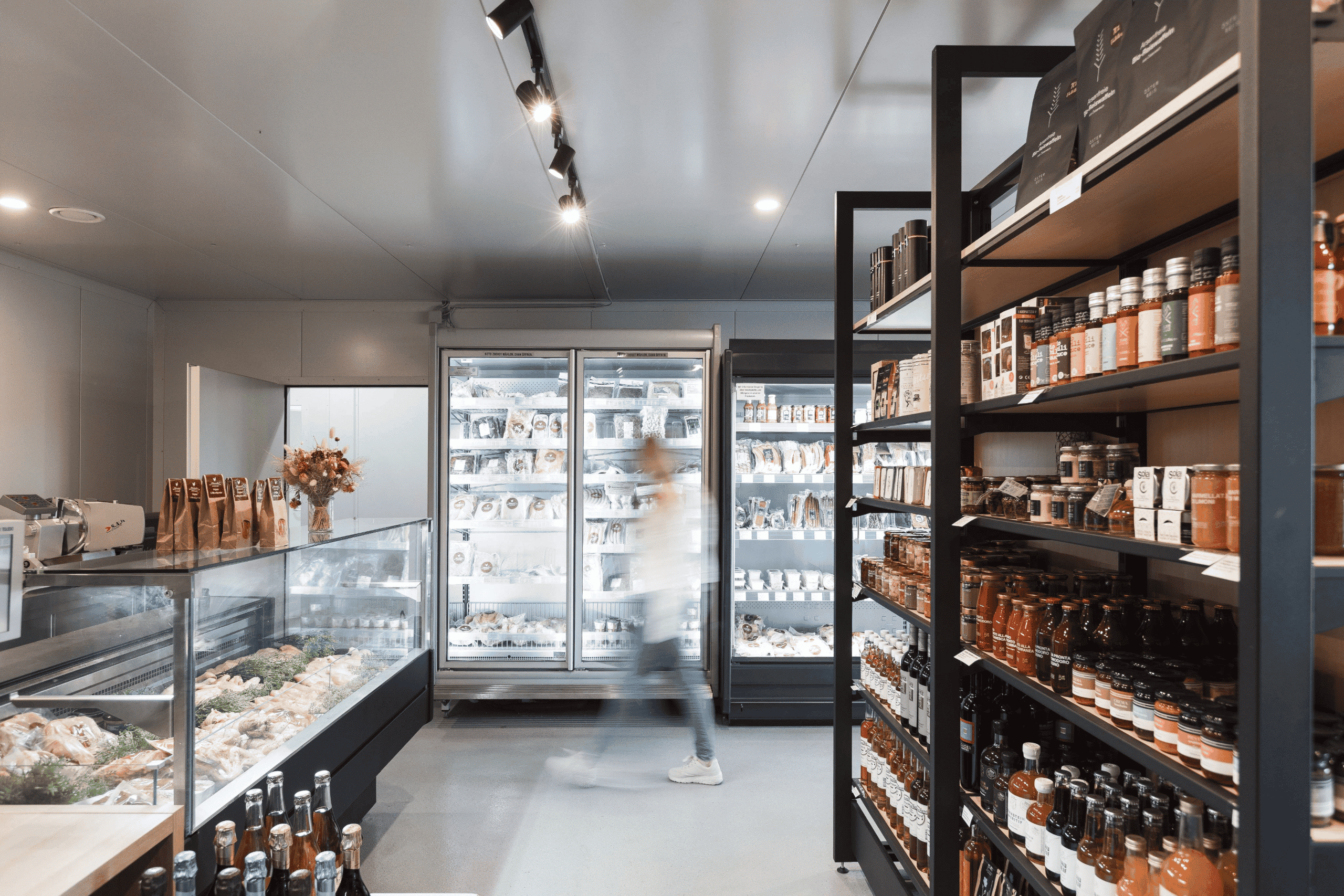 Innenansicht der Greißlerei mit Regalen voller italienischer Feinkost, Kühlvitrine und Feinkosttheke